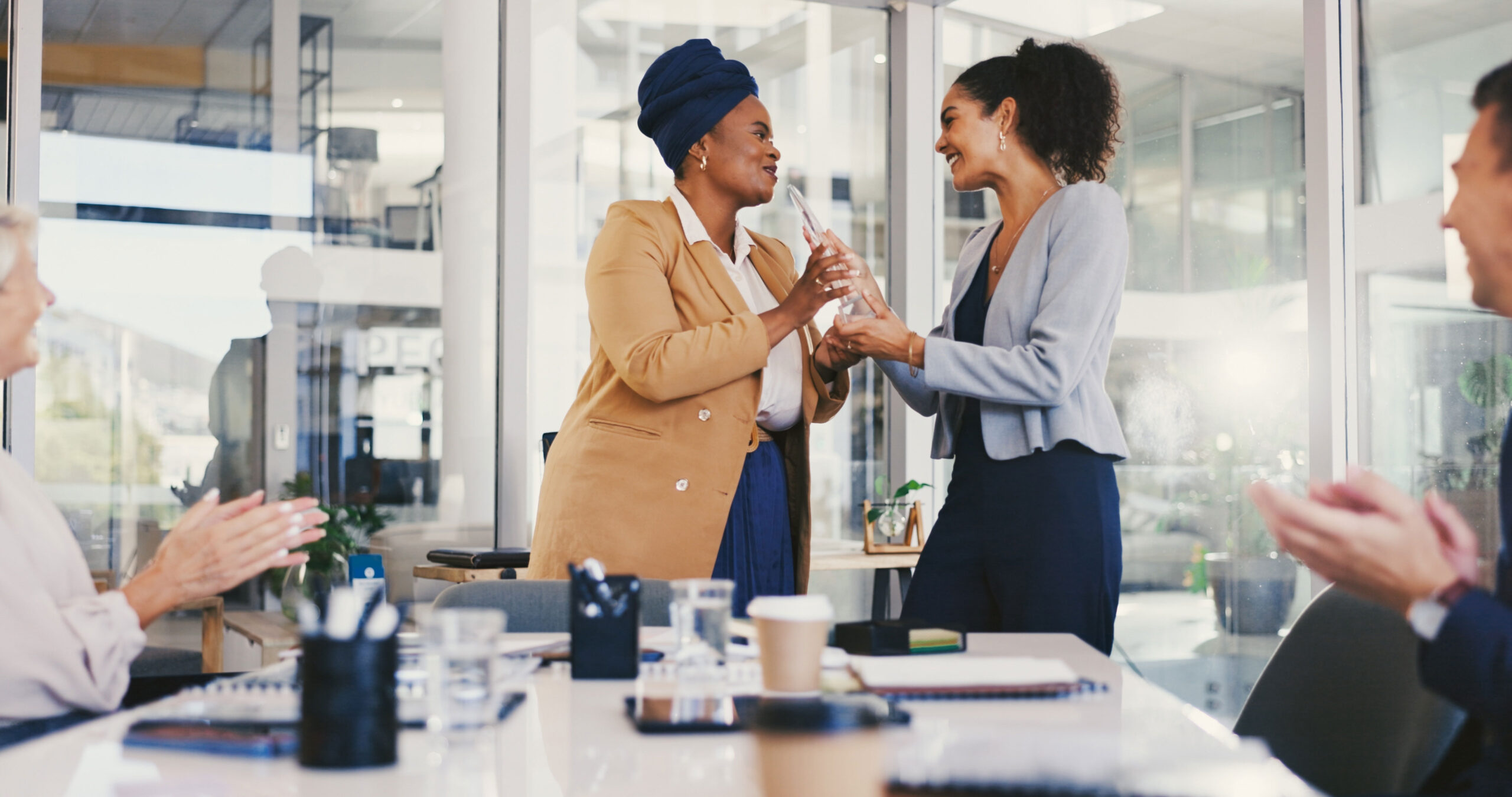 Employees meet and recognize one another, giving applause and smiling.