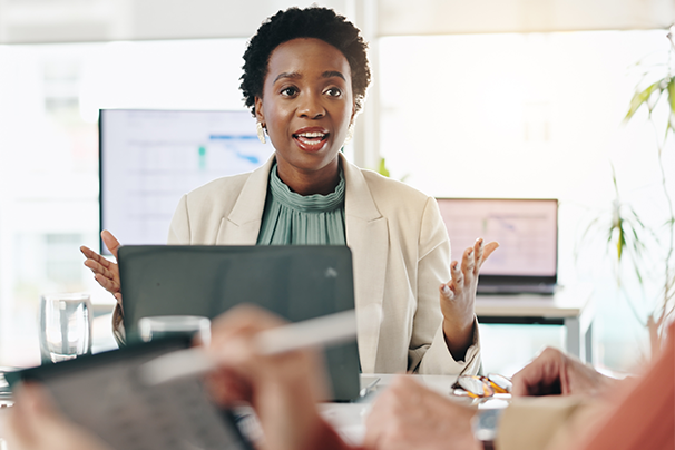 A female manager sits in a meeting with her team.